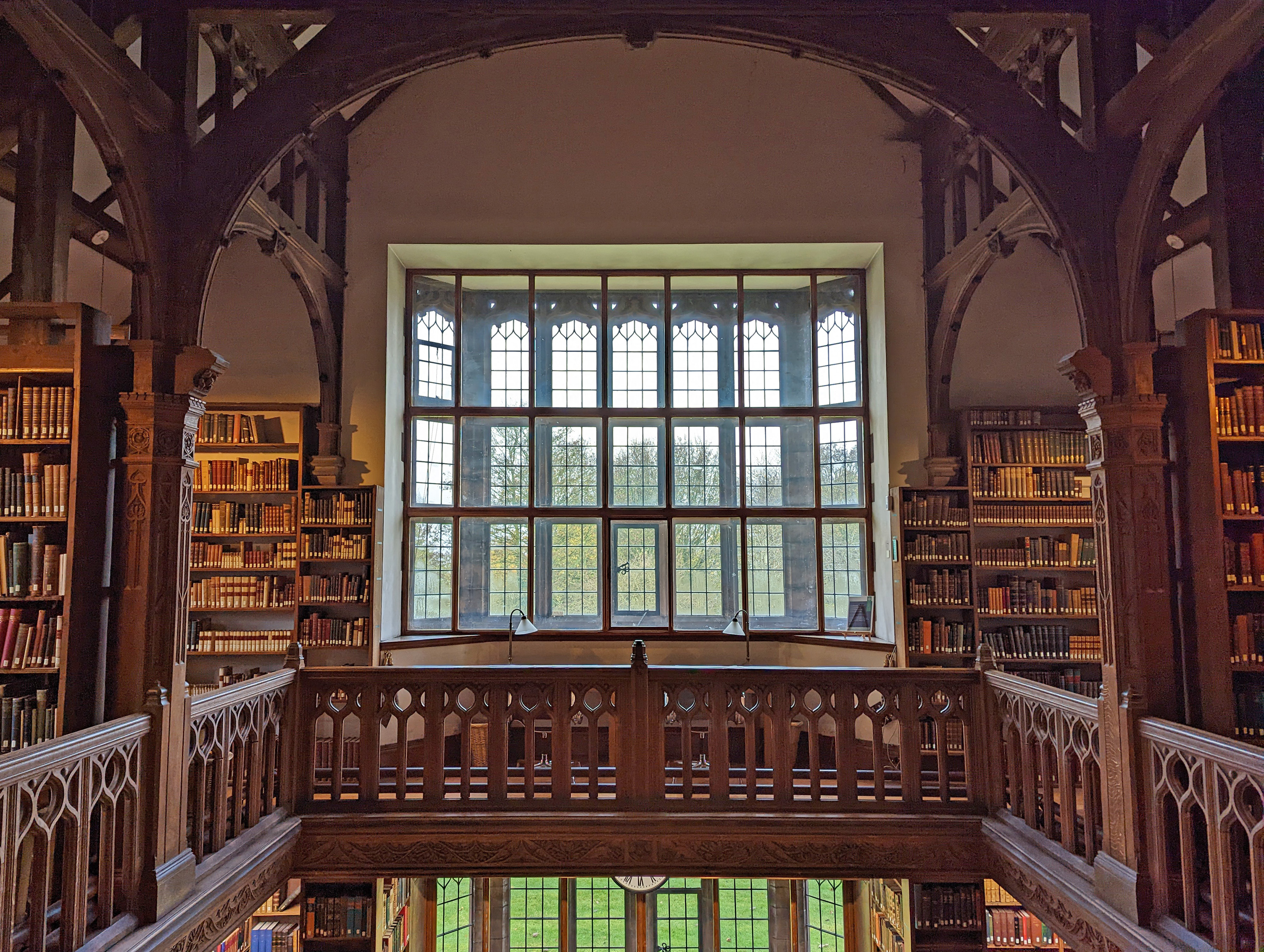 A shot from the top gallery of the Theology Room. It shows pillars, baulstrades, bookshelves and windows at the far end