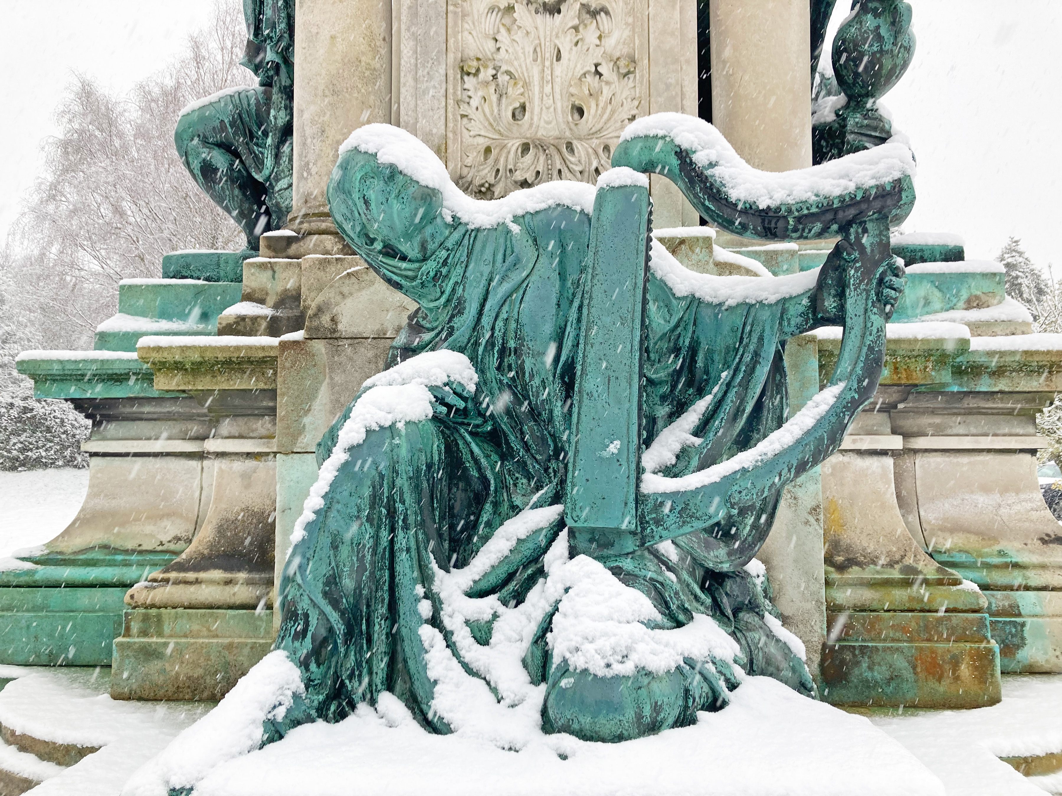 Erin, a copper statue of a woman harper. It is covered in snow