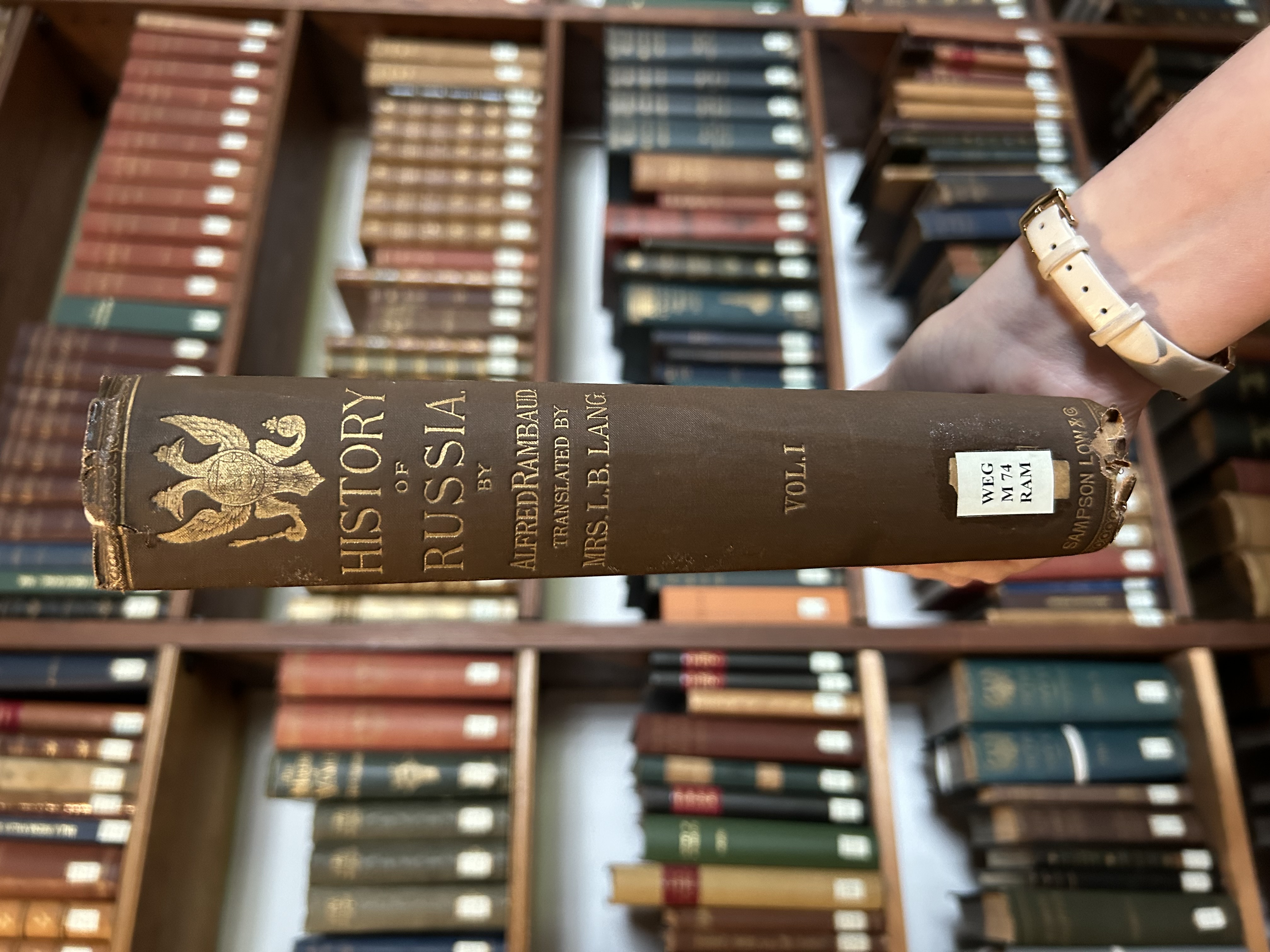 A copy of History of Russia as mentioned in the body text. It is held up in front of a set of bookshelves. The book itself has a blue spine and the title is picked out in gold